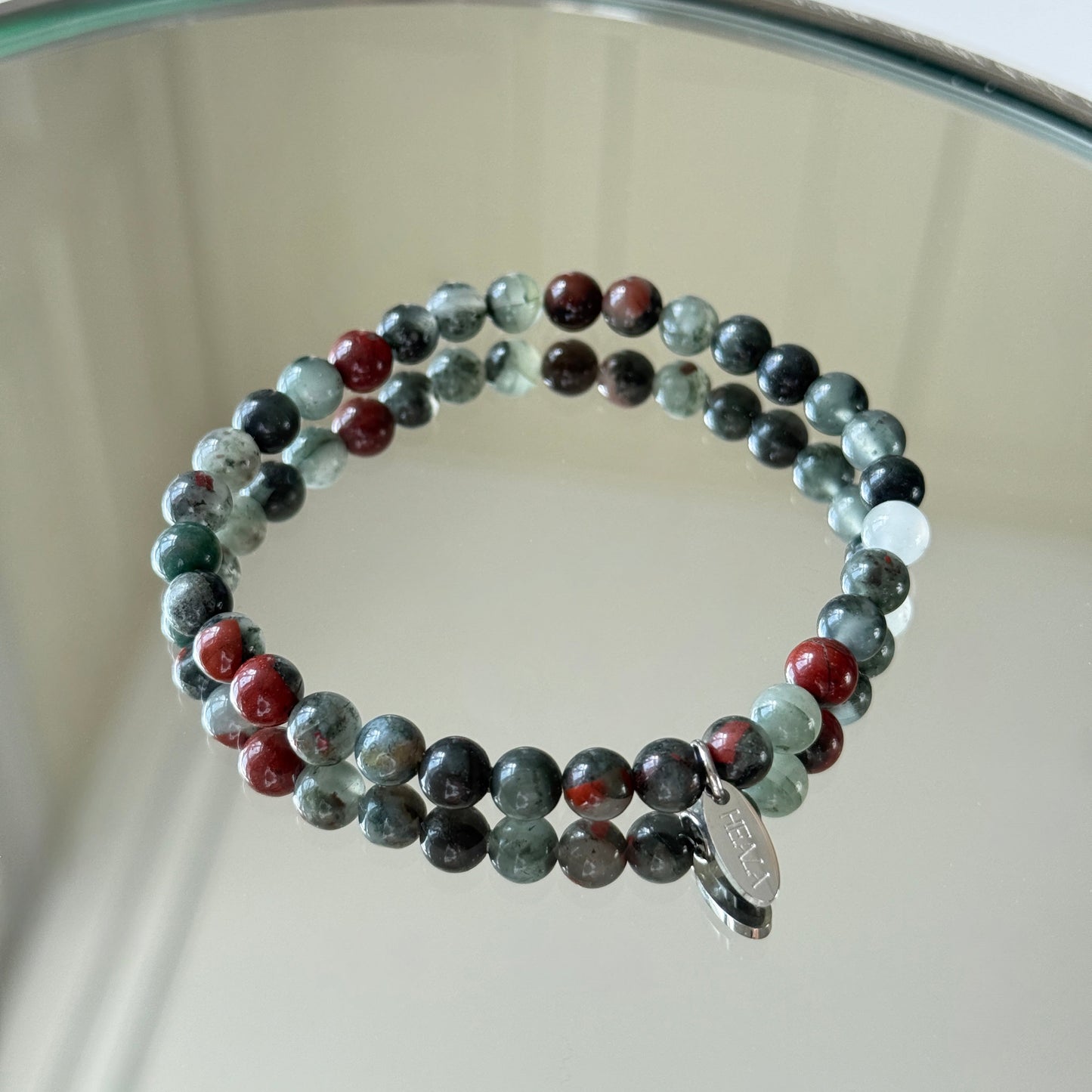Multicolored beaded bracelet on a reflective surface